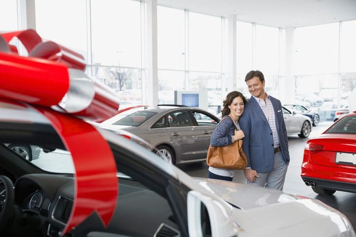 Gill Insurance | Couple shopping in car dealership showroom